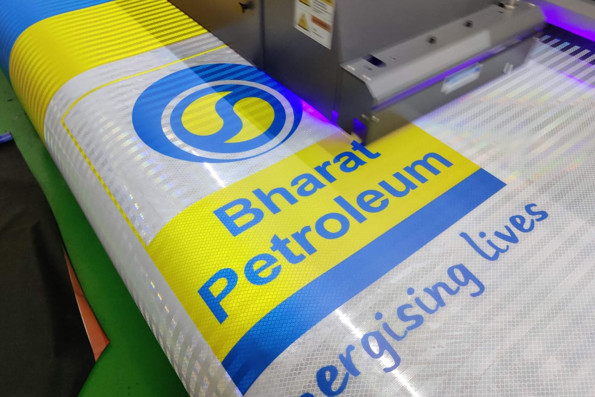 UV printer head printing a blue and yellow Bharat Petroleum logo onto retroreflective sheeting.