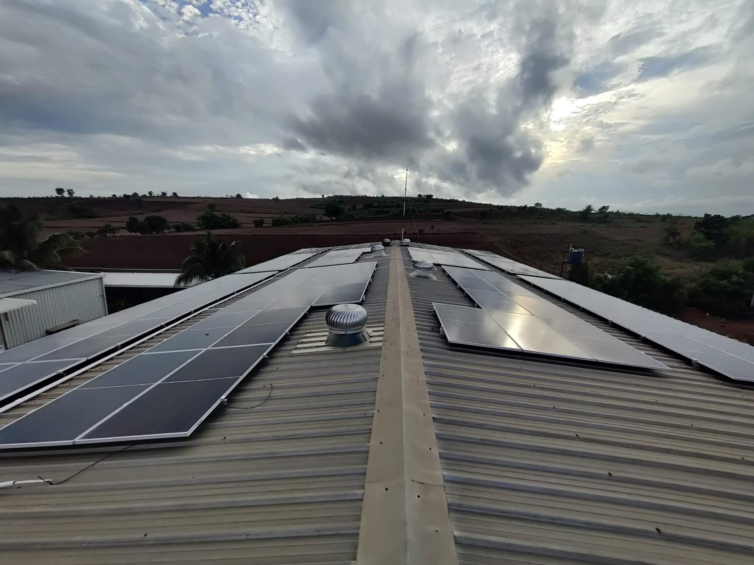 Rooftop solar panels over the Dharwad production shed at dusk